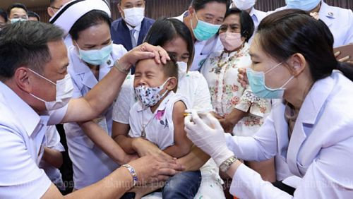 Глава Минздрава Анутин Чарнвиракун успокаивает ребенка, прививаемого 12 октября в Нонтхабури. Фото: Pornprom Satrabhaya / Bangkok Post