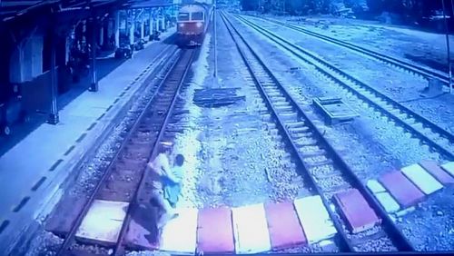 Станционный смотритель спас переходившую рельсы женщину в Сураттхани утром 30 апреля. Фото: State Railway of Thailand