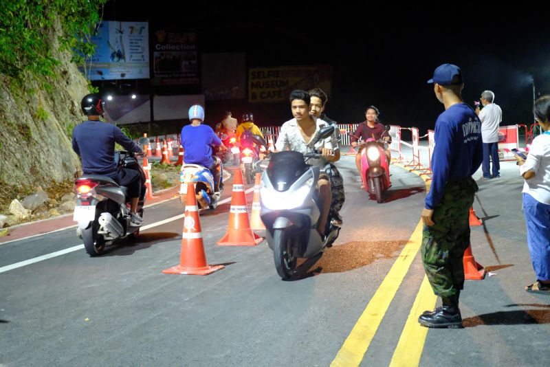 Открытие мотоциклетного движения мимо провала на холме в Патонге. Шлемы есть далеко не у всех мотоциклистов, полиция смотрит на это спокойно. Фото: PR Patong