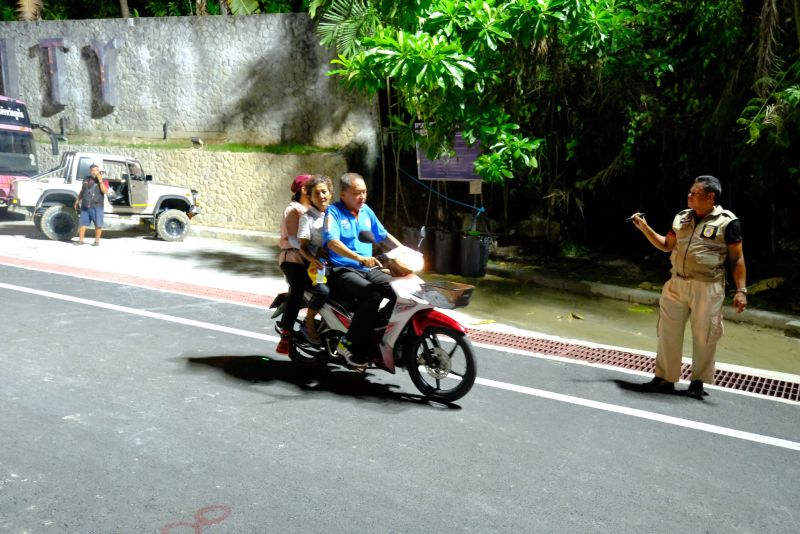 Открытие мотоциклетного движения мимо провала на холме в Патонге. Шлемы есть далеко не у всех мотоциклистов, полиция смотрит на это спокойно. Фото: PR Patong